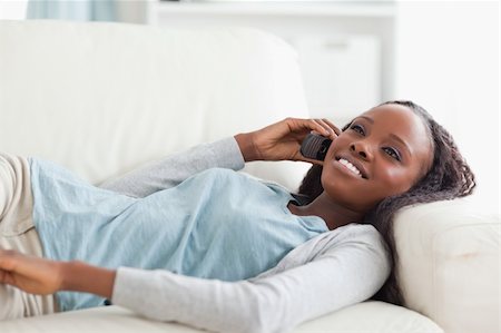 simsearch:400-05716936,k - Smiling woman lying on sofa with phone Stock Photo - Budget Royalty-Free & Subscription, Code: 400-05716931