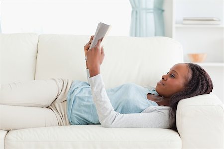 simsearch:400-05716909,k - Young woman on sofa reading a novel Stock Photo - Budget Royalty-Free & Subscription, Code: 400-05716942