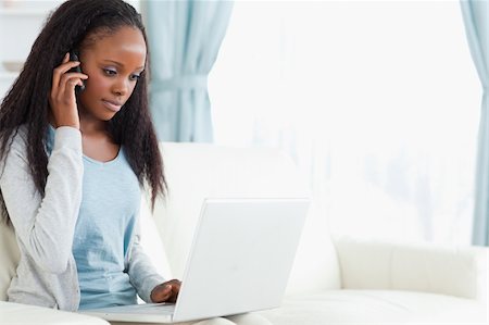 Young woman on the phone while using laptop Stock Photo - Budget Royalty-Free & Subscription, Code: 400-05717079