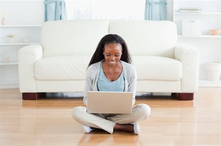 Smiling woman sitting on floor with notebook Stock Photo - Budget Royalty-Free & Subscription, Code: 400-05717165