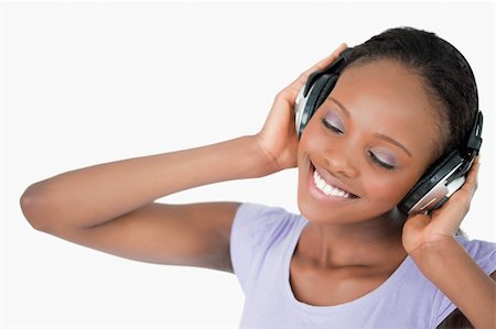 simsearch:400-05717354,k - Close up of smiling woman listening to music against a white background Stock Photo - Budget Royalty-Free & Subscription, Code: 400-05717448