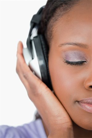 simsearch:400-05717354,k - Close up of young woman enjoying music against a white background Stock Photo - Budget Royalty-Free & Subscription, Code: 400-05717449