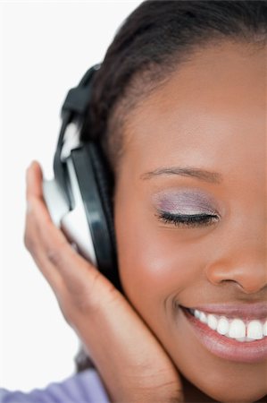 simsearch:400-05717354,k - Close up of smiling young woman listening to music on white background Stock Photo - Budget Royalty-Free & Subscription, Code: 400-05717451