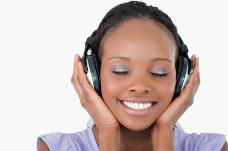 simsearch:400-05717354,k - Close up of smiling young woman listening to music with headphones on white background Stock Photo - Budget Royalty-Free & Subscription, Code: 400-05717453