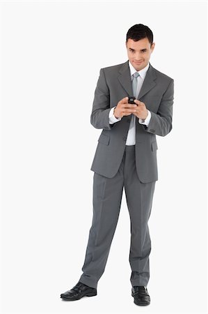 simsearch:400-04608943,k - Smiling businessman holding his cellphone against a white background Stock Photo - Budget Royalty-Free & Subscription, Code: 400-05718073