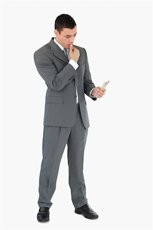 Businessman taking a close look at banknotes against a white background Stock Photo - Budget Royalty-Free & Subscription, Code: 400-05718108