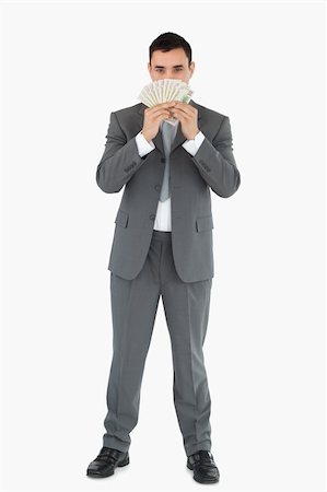 simsearch:400-05718322,k - Businessman smelling banknotes against a white background Fotografie stock - Microstock e Abbonamento, Codice: 400-05718103