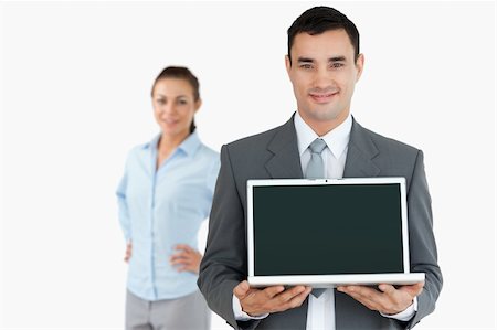 simsearch:400-04918393,k - Businessman presenting laptop with businesswoman in the background against a white background Stock Photo - Budget Royalty-Free & Subscription, Code: 400-05718169