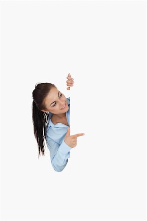 eye pointing - Businesswoman pointing while looking around the corner against a white background Stock Photo - Budget Royalty-Free & Subscription, Code: 400-05718227