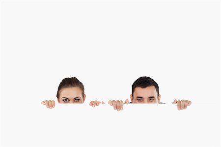 simsearch:400-05718227,k - Business partners hiding behind a sign against a white background Stock Photo - Budget Royalty-Free & Subscription, Code: 400-05718221