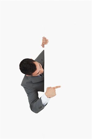 simsearch:400-05718227,k - Businessman looking around the corner and pointing against a white background Stock Photo - Budget Royalty-Free & Subscription, Code: 400-05718231