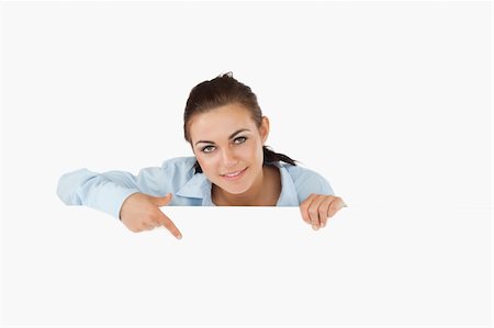 simsearch:400-05718227,k - Businesswoman pointing on sign under her against a white background Stock Photo - Budget Royalty-Free & Subscription, Code: 400-05718241