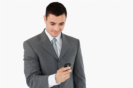 simsearch:400-05718346,k - Businessman texting with his cellphone against a white background Foto de stock - Super Valor sin royalties y Suscripción, Código: 400-05718313