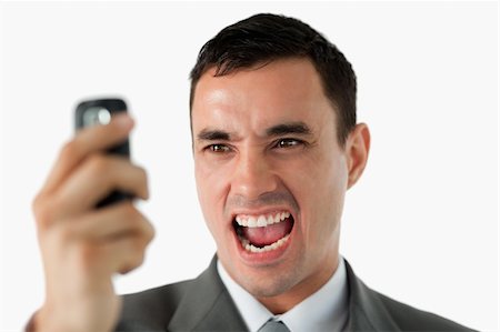 simsearch:400-04608943,k - Close up of businessman upset about text message against a white background Stock Photo - Budget Royalty-Free & Subscription, Code: 400-05718405