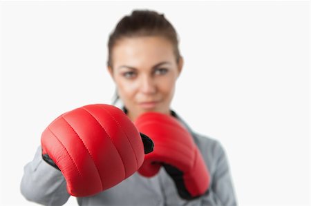 simsearch:400-05898249,k - Boxing gloves used to slam by young businesswoman against a white background Stock Photo - Budget Royalty-Free & Subscription, Code: 400-05718455