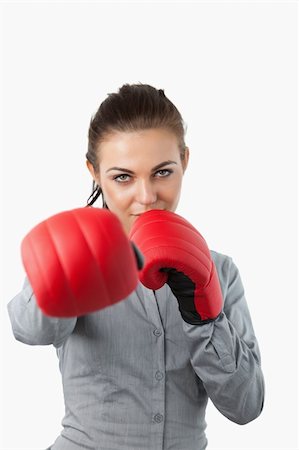 simsearch:400-05898249,k - Businesswoman with boxing gloves slamming against a white background Stock Photo - Budget Royalty-Free & Subscription, Code: 400-05718453