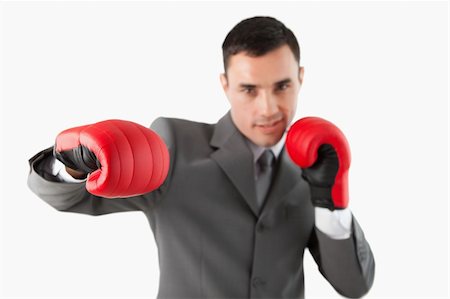 simsearch:400-05718453,k - Close up of businessman with boxing gloves striking a hook against a white background Stock Photo - Budget Royalty-Free & Subscription, Code: 400-05718485