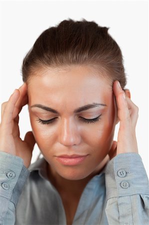Close up of businesswoman suffering from a headache against a white background Stock Photo - Budget Royalty-Free & Subscription, Code: 400-05718480