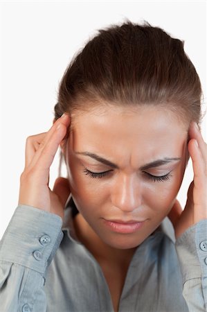 Close up of businesswoman having a headache against a white background Stock Photo - Budget Royalty-Free & Subscription, Code: 400-05718482