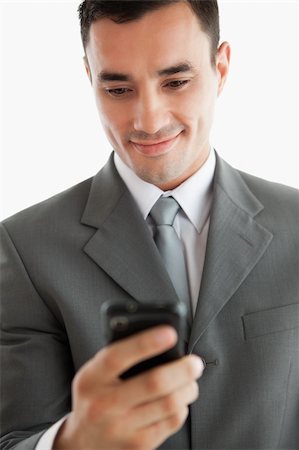 simsearch:400-05718346,k - Close up of businessman writing text message on his phone against a white background Foto de stock - Super Valor sin royalties y Suscripción, Código: 400-05718517