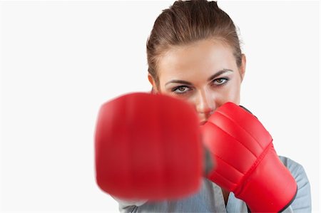 simsearch:400-05718453,k - Close up of businesswoman striking with boxing gloves against a white background Stock Photo - Budget Royalty-Free & Subscription, Code: 400-05718540