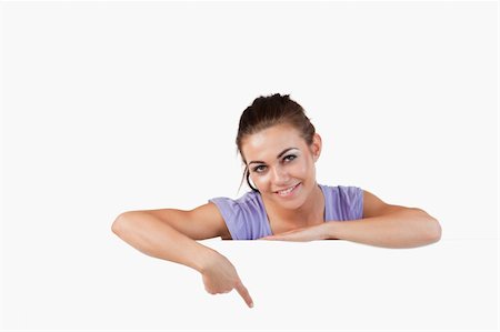 Young female pointing at banner below her against a white background Stock Photo - Budget Royalty-Free & Subscription, Code: 400-05718734