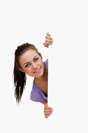 Young female looking around the corner against a white background Stock Photo - Budget Royalty-Free & Subscription, Code: 400-05718736