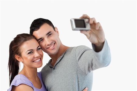 simsearch:400-04151970,k - Young couple taking a picture of themselves against a white background Fotografie stock - Microstock e Abbonamento, Codice: 400-05718759