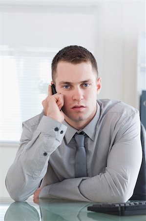 simsearch:400-05709706,k - Young businessman getting a serious call on his cellphone Stock Photo - Budget Royalty-Free & Subscription, Code: 400-05710250