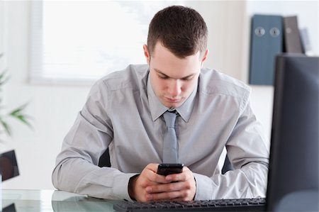 simsearch:400-05709706,k - Young businessman writing a textmessage Stock Photo - Budget Royalty-Free & Subscription, Code: 400-05710271