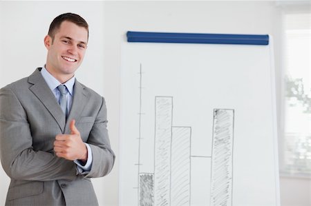 simsearch:400-05710385,k - Smiling businessman giving thumb up next to diagram Foto de stock - Royalty-Free Super Valor e Assinatura, Número: 400-05710382