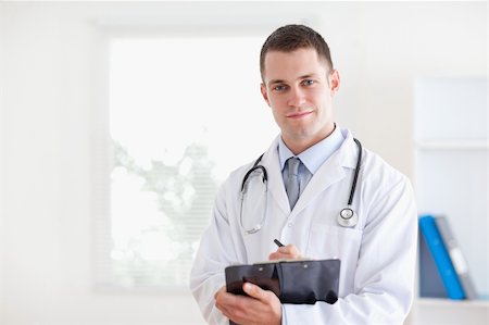 simsearch:400-05710928,k - Confident doctor taking notes Stockbilder - Microstock & Abonnement, Bildnummer: 400-05710395