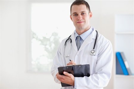 simsearch:400-05710928,k - Confident young doctor taking notes Stockbilder - Microstock & Abonnement, Bildnummer: 400-05710396