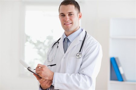 simsearch:400-05710928,k - Smiling doctor listening and taking notes Stockbilder - Microstock & Abonnement, Bildnummer: 400-05710405