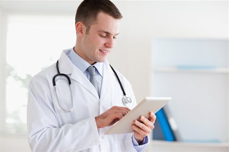 simsearch:400-05710928,k - Smiling doctor using tablet Stockbilder - Microstock & Abonnement, Bildnummer: 400-05710414