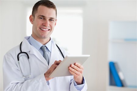 simsearch:400-05710928,k - Smiling young doctor with his tablet Stockbilder - Microstock & Abonnement, Bildnummer: 400-05710417