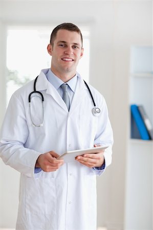 simsearch:400-05710928,k - Smiling doctor carrying a tablet Stockbilder - Microstock & Abonnement, Bildnummer: 400-05710418