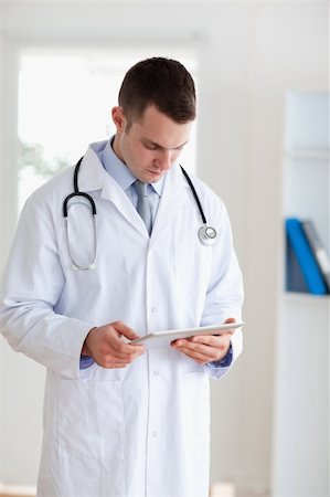 simsearch:400-05710928,k - Doctor having a close look at his tablet Stockbilder - Microstock & Abonnement, Bildnummer: 400-05710419