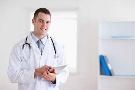 simsearch:400-05710928,k - Smiling doctor with his notepad Stockbilder - Microstock & Abonnement, Bildnummer: 400-05710411