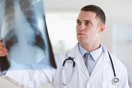 simsearch:400-05710928,k - Doctor having a serious look at x-ray in his hand Stockbilder - Microstock & Abonnement, Bildnummer: 400-05710430