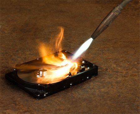 burning a hard disk drive with a welding torch in rusty background Photographie de stock - Aubaine LD & Abonnement, Code: 400-05710472