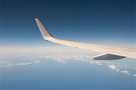 flap - View from a large aircraft in flight with the wing against a blue sky background Foto de stock - Super Valor sin royalties y Suscripción, Código: 400-05710907