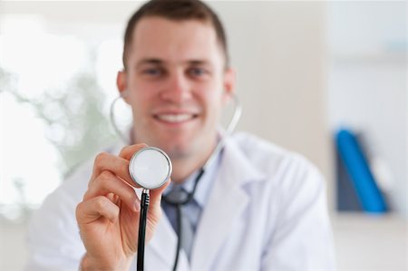 simsearch:400-05710928,k - Smiling young doctor using stethoscope Stockbilder - Microstock & Abonnement, Bildnummer: 400-05710929