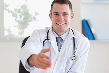 simsearch:400-05710928,k - Smiling doctor welcoming patient Stockbilder - Microstock & Abonnement, Bildnummer: 400-05710921