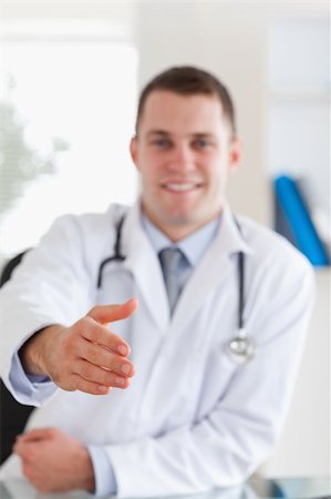 simsearch:400-05710928,k - Smiling doctor offering his hand Stockbilder - Microstock & Abonnement, Bildnummer: 400-05710923