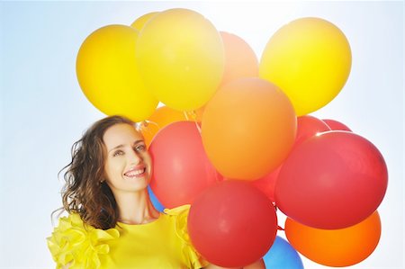 Woman holding balloons against sun and sky Photographie de stock - Aubaine LD & Abonnement, Code: 400-05711585