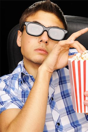 Young man watching movie in 3D glasses at cinema Stock Photo - Budget Royalty-Free & Subscription, Code: 400-05711631