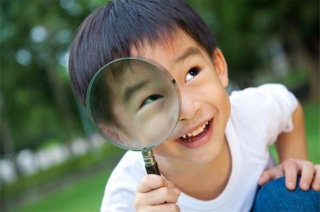 asian boy holding magnifier Stock Photo - Budget Royalty-Free & Subscription, Code: 400-05713752