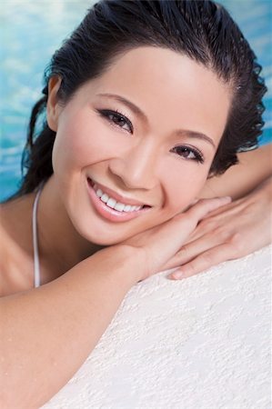 A beautiful sexy young Chinese Asian Oriental woman wearing a bikini and relaxing on the side of a swimming pool. Foto de stock - Super Valor sin royalties y Suscripción, Código: 400-05727753