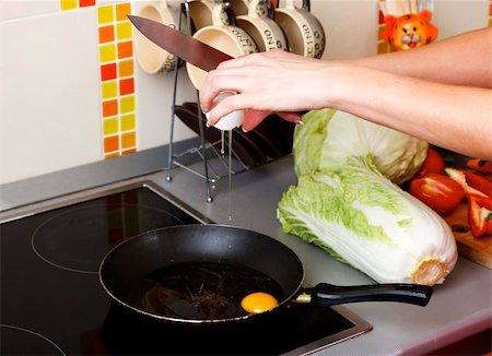 person frying eggs - Woman cracking eggs into frying pan in kitchen Stock Photo - Budget Royalty-Free & Subscription, Code: 400-05728563